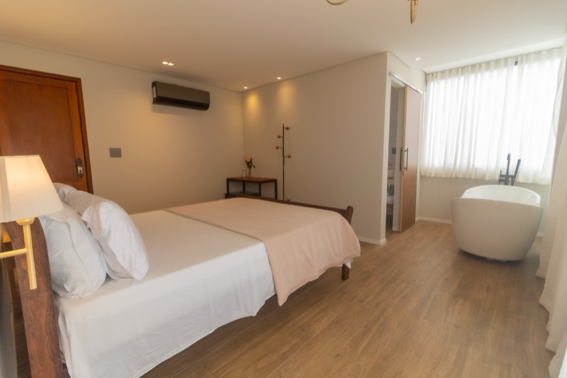Suíte com cama queen e banheira de imersão ao fundo