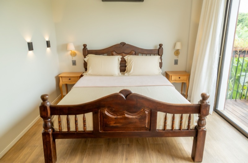 Cama queen com cabeceira de madeira trabalhada
